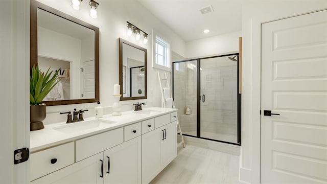bathroom with a stall shower and double vanity