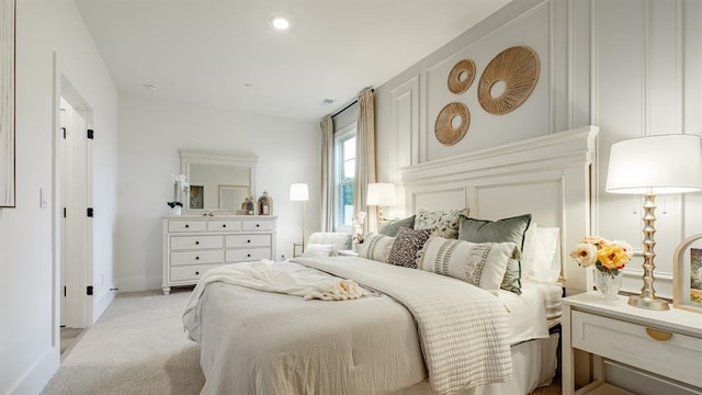 bedroom with light colored carpet and baseboards