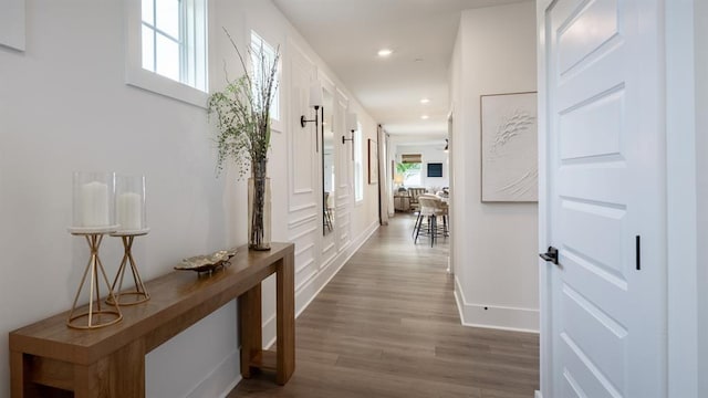 hall with dark wood-type flooring, recessed lighting, and baseboards
