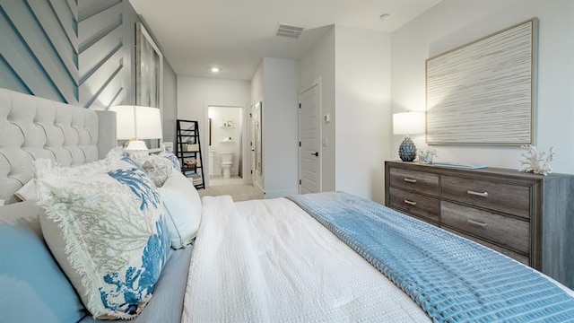 bedroom with ensuite bath and recessed lighting