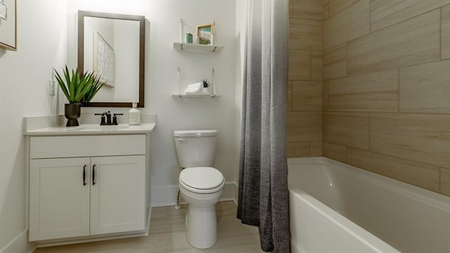 full bath featuring toilet, baseboards, vanity, and shower / bath combo