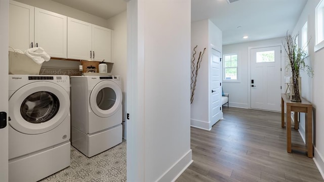 clothes washing area with washer and dryer, cabinet space, baseboards, light wood-type flooring, and recessed lighting