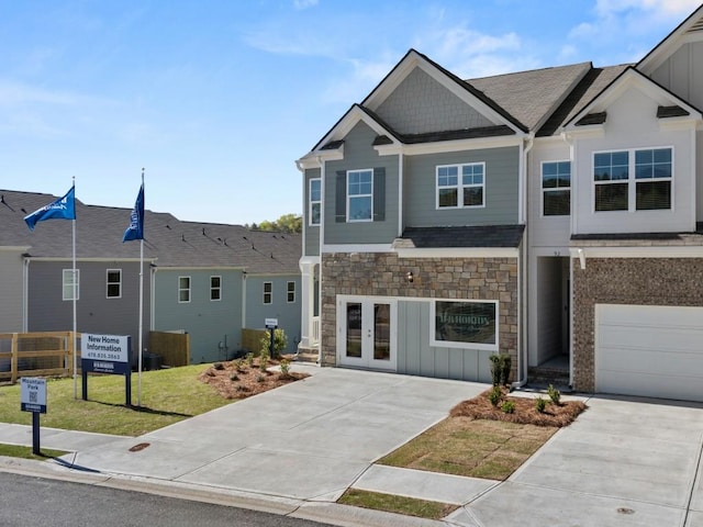 multi unit property featuring a front lawn, a garage, and french doors