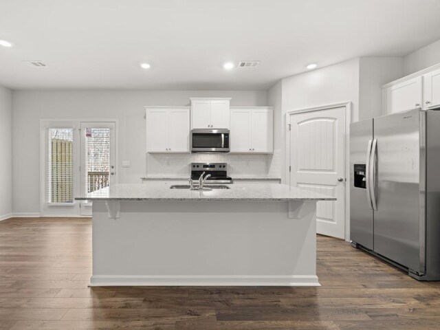 kitchen featuring visible vents, backsplash, appliances with stainless steel finishes, dark wood-type flooring, and a sink