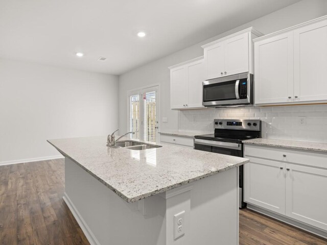 kitchen with a kitchen breakfast bar, white cabinetry, stainless steel appliances, and a kitchen island with sink