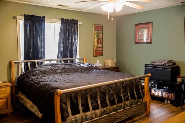 bedroom featuring hardwood / wood-style flooring, a textured ceiling, and ceiling fan