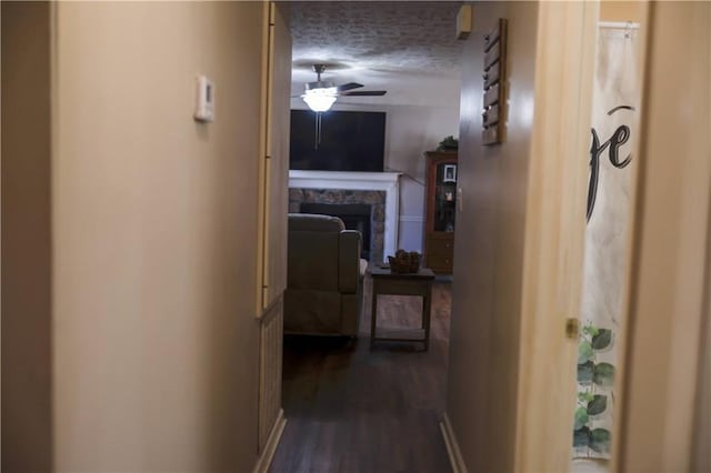 corridor with dark hardwood / wood-style floors and a textured ceiling