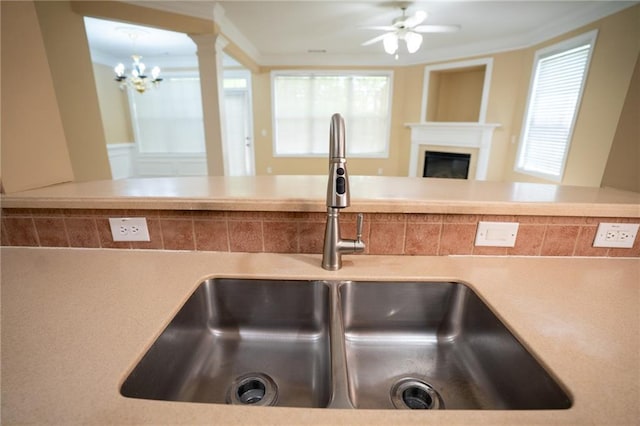 2548 Gadsen Walk, Duluth, GA 30097 - interior details featuring a glass covered fireplace, a sink, light countertops, and ceiling fan with notable chandelier