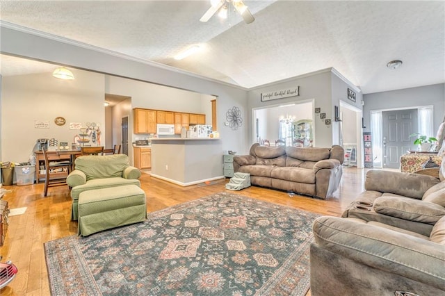 living room featuring a textured ceiling, lofted ceiling, light hardwood / wood-style floors, ornamental molding, and ceiling fan