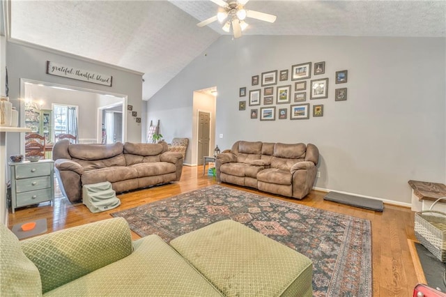 living room with hardwood / wood-style flooring, a textured ceiling, ceiling fan, and vaulted ceiling