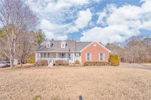 new england style home with a porch and a front lawn