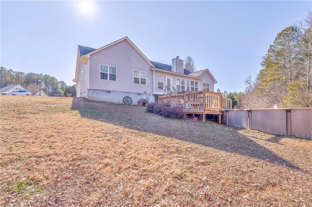 rear view of property with a yard and a deck