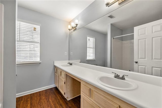 bathroom with plenty of natural light, a shower, wood-type flooring, and vanity