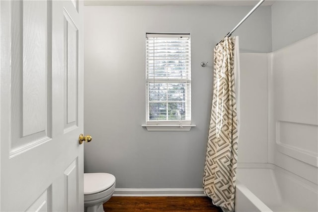 bathroom with toilet, hardwood / wood-style flooring, and shower / bath combo with shower curtain