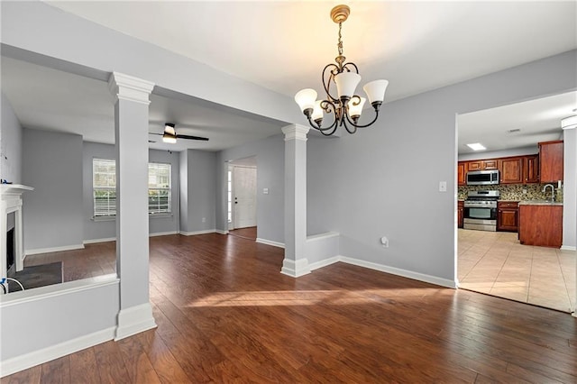 unfurnished living room with light hardwood / wood-style flooring and ceiling fan with notable chandelier