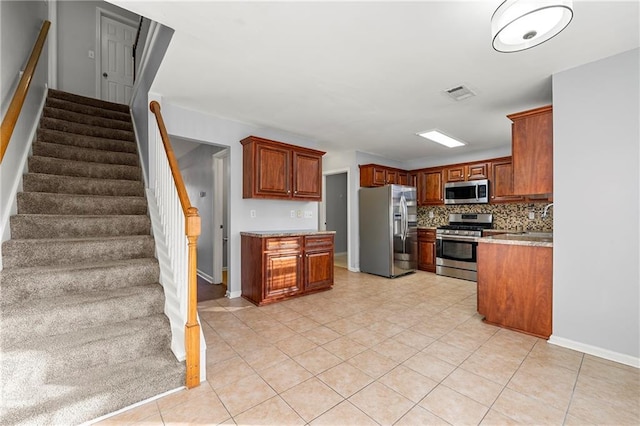 kitchen featuring stainless steel appliances, light tile patterned floors, sink, and backsplash