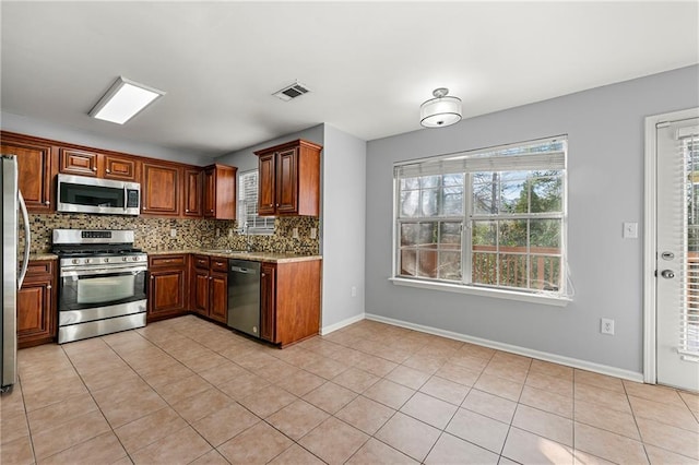 kitchen featuring stainless steel appliances, sink, light stone counters, light tile patterned floors, and decorative backsplash