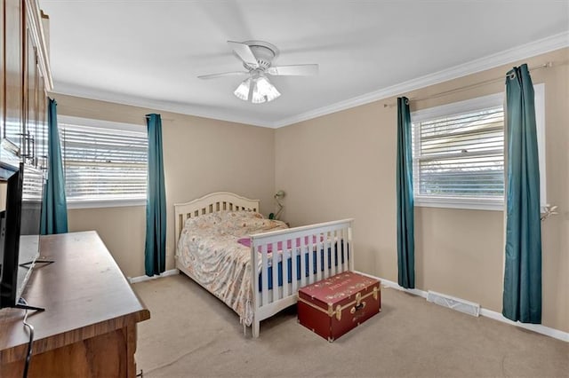 bedroom with multiple windows, crown molding, light colored carpet, and ceiling fan