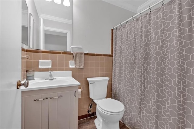 bathroom with toilet, tile walls, ornamental molding, vanity, and curtained shower