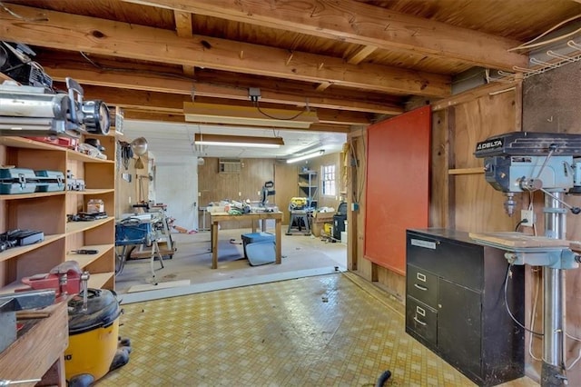 basement featuring wood walls and a workshop area