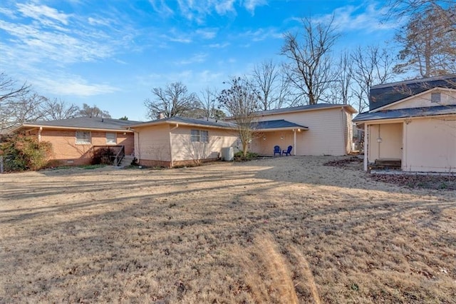 rear view of property featuring a lawn