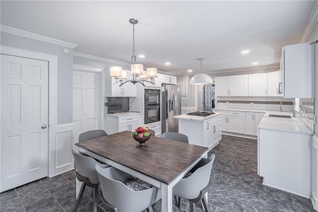 dining room with crown molding, sink, and an inviting chandelier