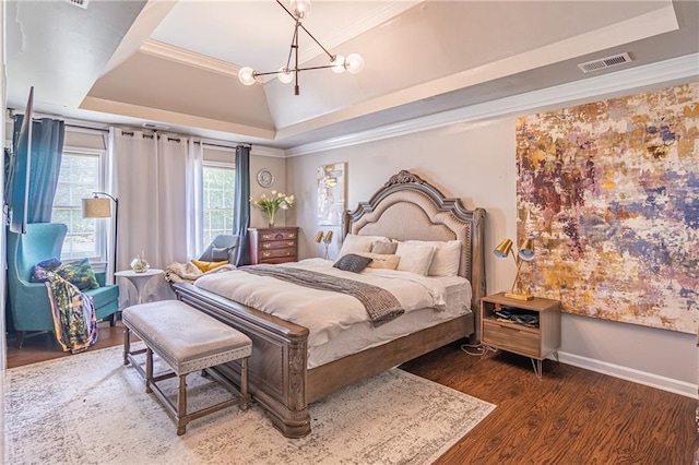 bedroom with a tray ceiling, crown molding, a chandelier, and dark wood-type flooring