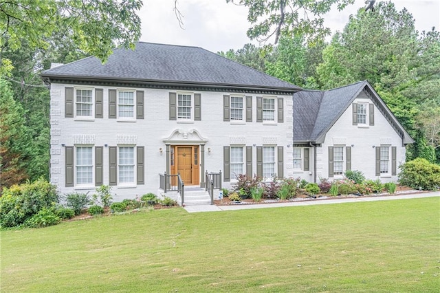 colonial house featuring a front lawn