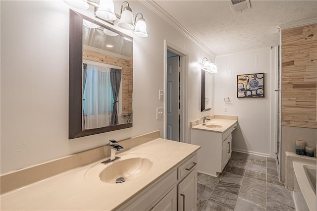 bathroom with a bathing tub, vanity, ornamental molding, and a textured ceiling