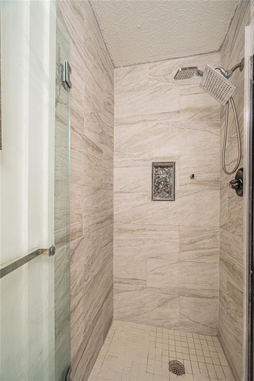 bathroom featuring a shower with door and a textured ceiling