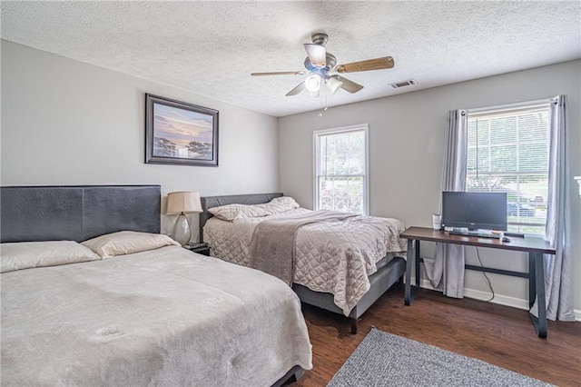 bedroom with multiple windows, dark hardwood / wood-style flooring, and ceiling fan