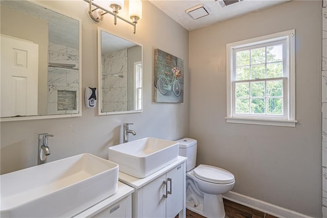 bathroom featuring walk in shower, vanity, wood-type flooring, and toilet