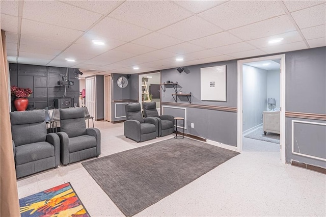 interior space with a paneled ceiling and a wood stove