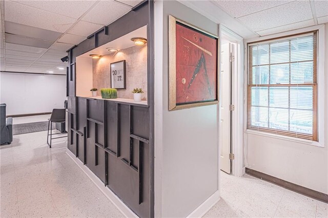 hall featuring a paneled ceiling