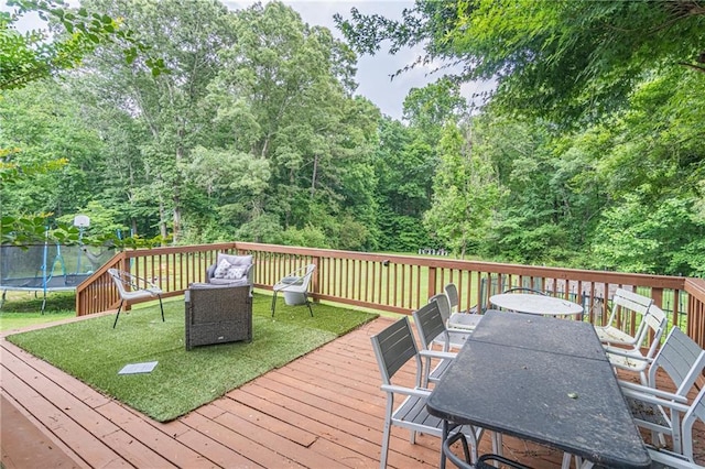 deck with a yard and a trampoline