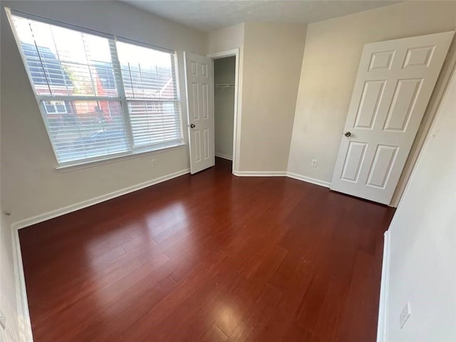 unfurnished bedroom with a closet and dark hardwood / wood-style flooring