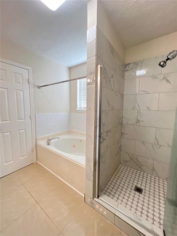 bathroom featuring shower with separate bathtub and a textured ceiling