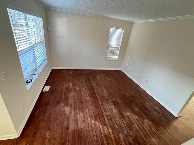 spare room featuring ornamental molding, dark hardwood / wood-style floors, and a textured ceiling