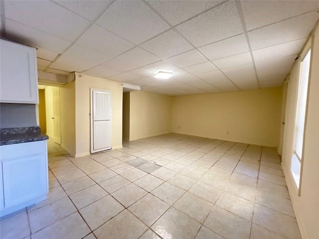 tiled empty room featuring a paneled ceiling