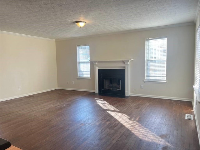 unfurnished living room with ornamental molding, plenty of natural light, dark wood-type flooring, and a textured ceiling