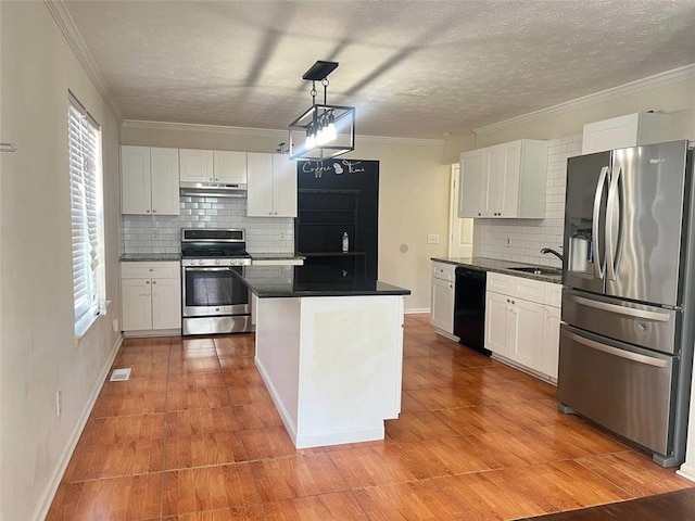 kitchen with white cabinetry, stainless steel appliances, a kitchen island, and decorative light fixtures