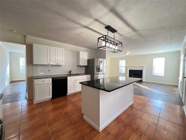 kitchen featuring white cabinets, stainless steel fridge, decorative light fixtures, and dishwasher