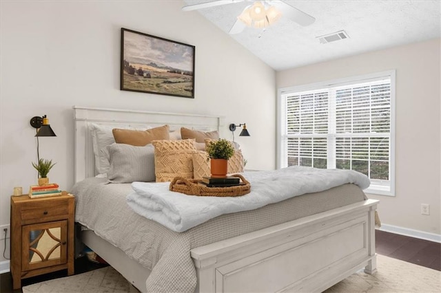 bedroom with baseboards, visible vents, a ceiling fan, lofted ceiling, and wood finished floors