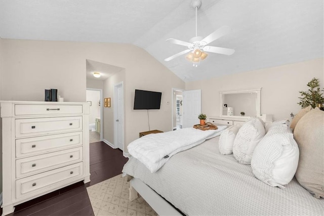 bedroom featuring dark wood-style floors, connected bathroom, vaulted ceiling, and ceiling fan