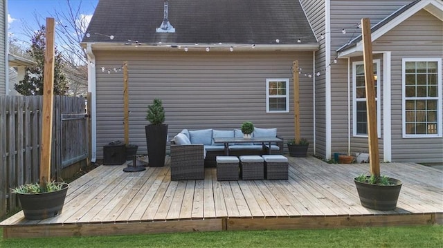 deck featuring outdoor lounge area and fence