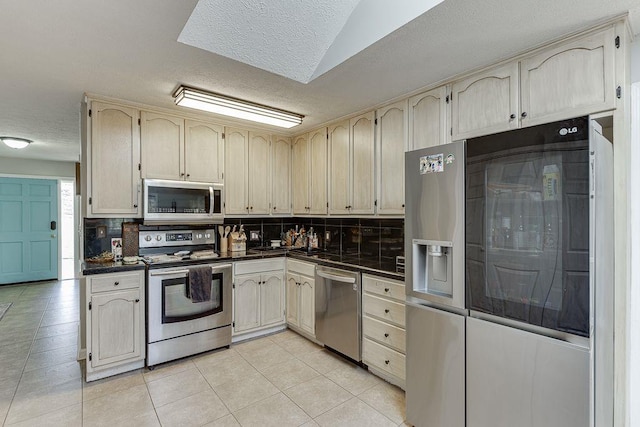 4434 Hidden Oaks Dr, Flowery Branch, GA 30542 - kitchen featuring appliances with stainless steel finishes, dark countertops, a textured ceiling, and decorative backsplash