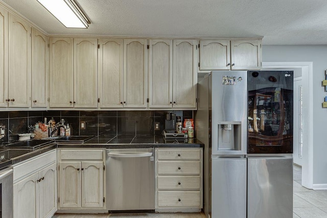 4434 Hidden Oaks Dr, Flowery Branch, GA 30542 - kitchen with appliances with stainless steel finishes, dark countertops, decorative backsplash, light tile patterned floors, and a textured ceiling