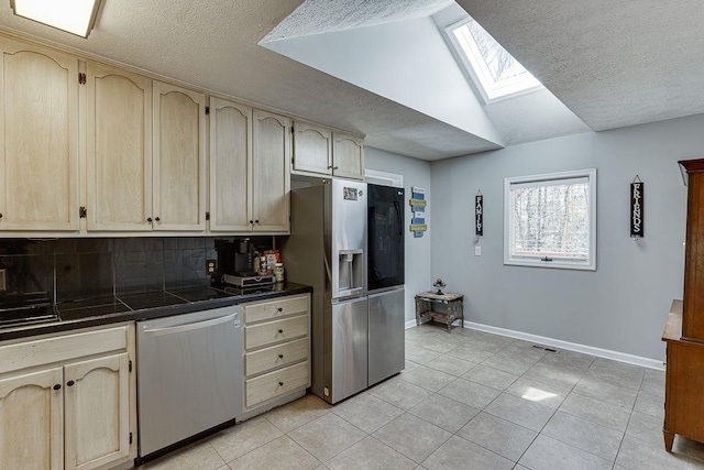 4434 Hidden Oaks Dr, Flowery Branch, GA 30542 - kitchen featuring stainless steel appliances, a skylight, decorative backsplash, light tile patterned flooring, and a textured ceiling