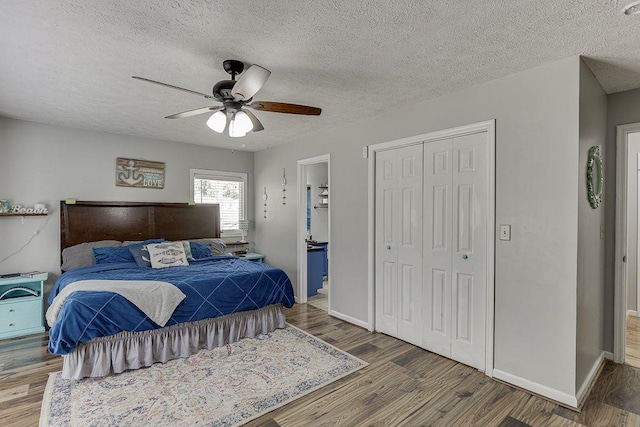 4434 Hidden Oaks Dr, Flowery Branch, GA 30542 - bedroom with a closet, wood finished floors, a textured ceiling, ceiling fan, and ensuite bathroom