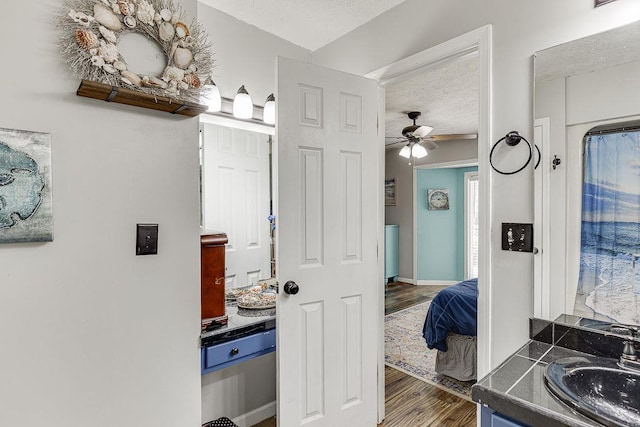 4434 Hidden Oaks Dr, Flowery Branch, GA 30542 - bathroom with vanity, wood finished floors, ceiling fan, ensuite bath, and a textured ceiling